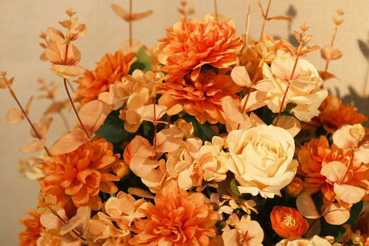 A vase filled with lots of orange and white flowers